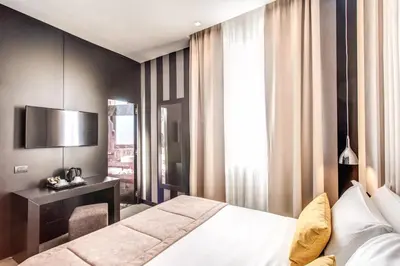 a bedroom with a bed and a desk and a television at Doria Palace Boutique Hotel in Rome