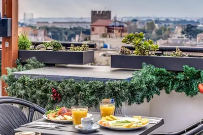 a table with plates of food and drinks on a balcony at Doria Palace Boutique Hotel in Rome