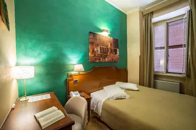 a hotel room with a bed and a table and a desk at Hotel Kent in Rome