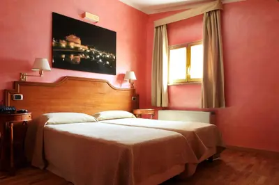 a bedroom with a large bed and a painting on the wall at Hotel Kent in Rome