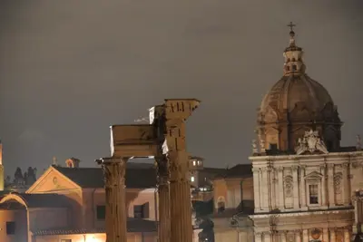 a building with a dome in front of a building at Hotel Kent in Rome