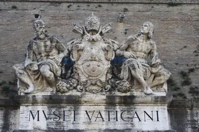 a statue of three men sitting on the side of a building at Tmark Hotel Vaticano in Rome