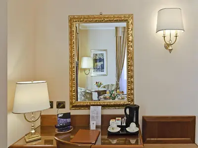 a desk with a lamp and a mirror at Tmark Hotel Vaticano in Rome