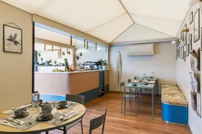 a restaurant with tables and chairs and a kitchen at Condominio Monti Boutique Hotel in Rome