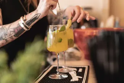 a person pours a drink into a glass at Condominio Monti Boutique Hotel in Rome