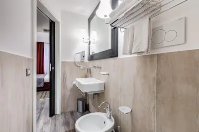 a bathroom with a sink and a toilet and a mirror at Residenza A -Via Veneto Fashion Rooms -self check-in in Rome