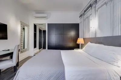 a bedroom with a large white bed and a desk at Residenza A -Via Veneto Fashion Rooms -self check-in in Rome