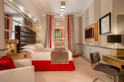a hotel room with a bed and a chair at Hotel Royal Court in Rome