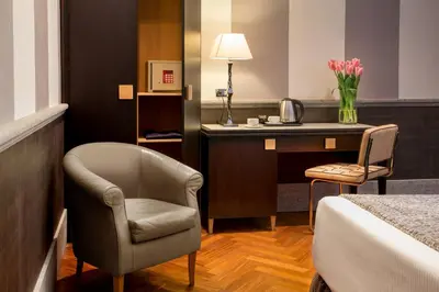 a hotel room with a bed and a desk and a chair at Hotel Royal Court in Rome