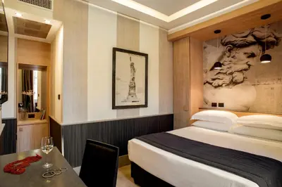a hotel room with a bed and a table with a glass of wine at Hotel Royal Court in Rome