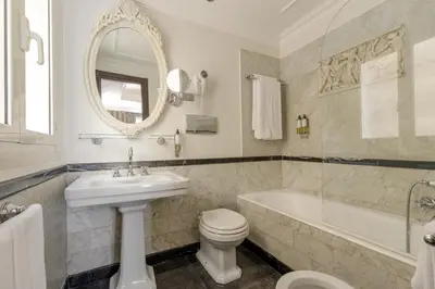 a bathroom with a sink and a tub and a toilet at Hotel Royal Court in Rome