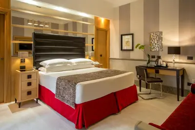 a bedroom with a large bed and a desk at Hotel Royal Court in Rome