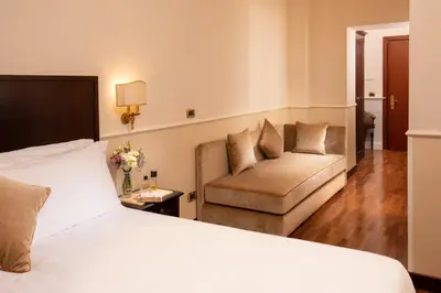 a hotel room with a bed and a couch at Hotel Del Corso in Rome