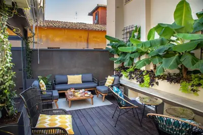 a patio with a couch and chairs and plants at Hotel Del Corso in Rome