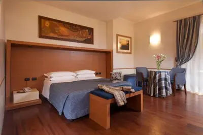 a hotel room with a bed and a table and chairs at Hotel Piemonte in Rome