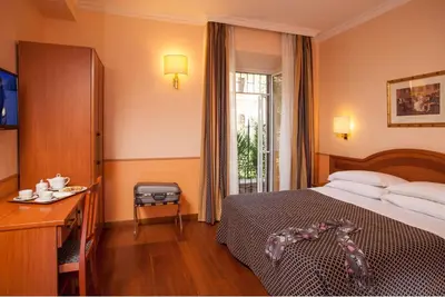 a bedroom with a bed and a table and a window at Hotel Piemonte in Rome