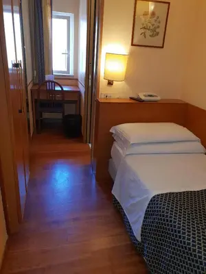 a hotel room with two beds and a table and a desk at Hotel Piemonte in Rome