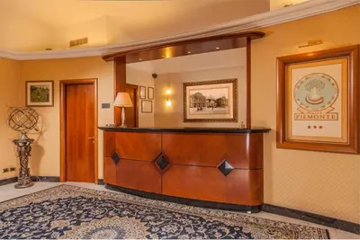 a lobby with a wooden reception desk in a room at Hotel Piemonte in Rome
