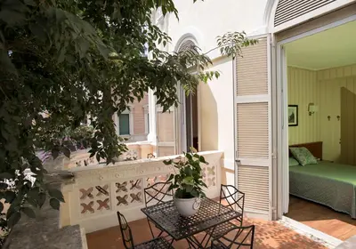 a patio with a table and chairs and a bed at Hotel Villa Delle Rose in Rome