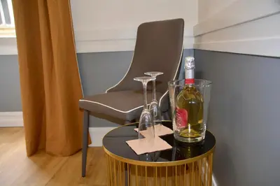 a chair and a bottle of wine on a table at Hotel Giotto Flavia in Rome
