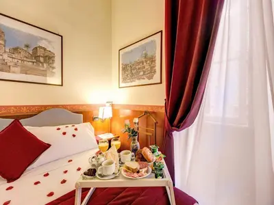 a hotel room with a tray of food on a bed at Hotel Giotto Flavia in Rome