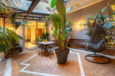 a patio with a table and chairs and plants at Hotel White in Rome