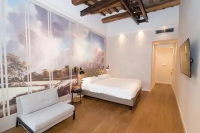 a bedroom with a bed and a chair at Hotel Accademia in Rome