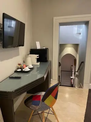 a room with a desk with a chair and a television at Hotel Accademia in Rome