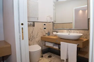 a bathroom with a sink and a toilet and a mirror at Hotel Accademia in Rome