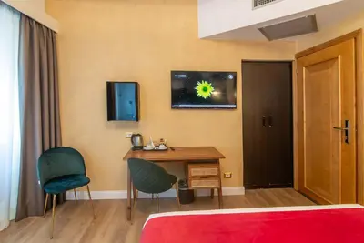 a bedroom with a desk and a table and chairs at Hotel Tritone in Rome