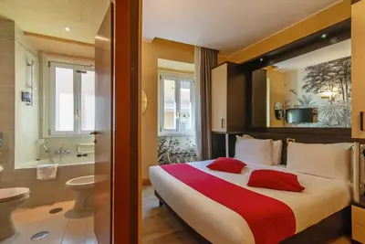 a hotel room with a large bed and a bathroom at Hotel Tritone in Rome