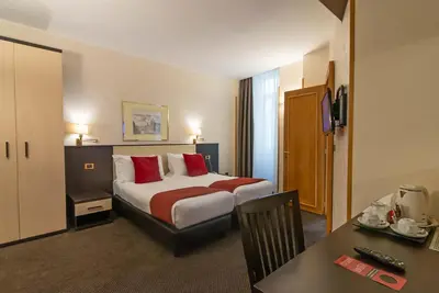 a hotel room with a bed and a table at Hotel Tritone in Rome