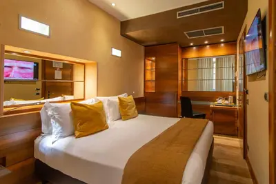 a bedroom with a large bed with yellow pillows at Hotel Tritone in Rome