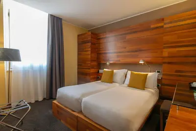 a hotel room with a large bed and a desk at Hotel Tritone in Rome