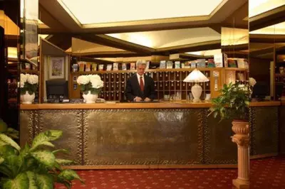 a man sitting at a bar in a library at Hotel Eliseo in Rome