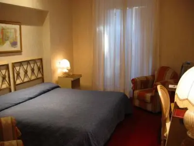a hotel room with a bed and a chair at Hotel Eliseo in Rome
