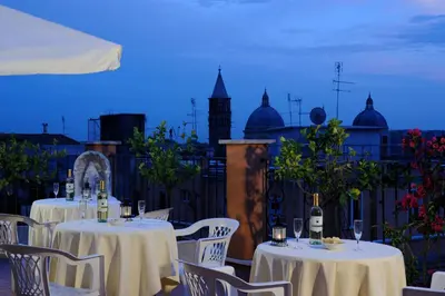 a group of tables with wine glasses on a balcony at Hotel Torino in Rome