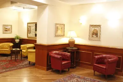 a waiting room with chairs and a table and a lamp at Hotel Torino in Rome