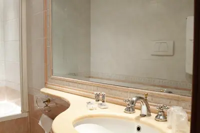 a bathroom with a sink and a mirror at Hotel Torino in Rome