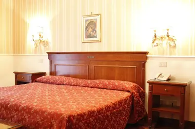 a hotel room with a bed and a telephone at Hotel Torino in Rome