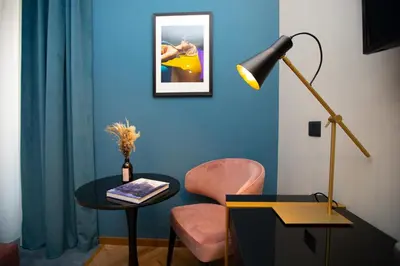 a room with a table and a chair and a lamp at The Major Hotel in Rome