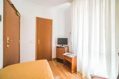 a bedroom with a bed and a tv and a window at GH Hotel San Giusto in Rome