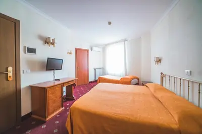 a hotel room with two beds and a television at GH Hotel San Giusto in Rome