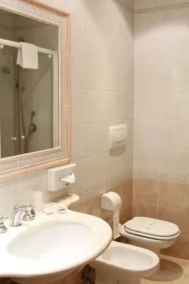 a bathroom with a sink and a toilet and a mirror at Hotel Pace Helvezia in Rome