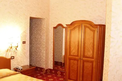 a bedroom with a wooden cabinet and a bed at Hotel Pace Helvezia in Rome