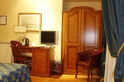 a bedroom with a desk with a computer and a television at Hotel Genio in Rome