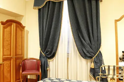 a bedroom with a curtain and a bed and a chair at Hotel Genio in Rome