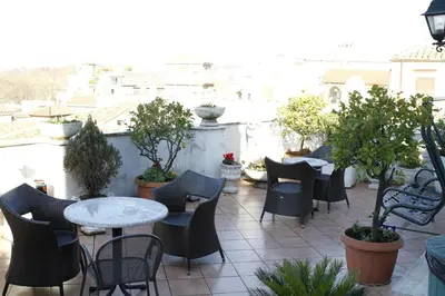 a patio with tables and chairs on a balcony at Hotel Genio in Rome