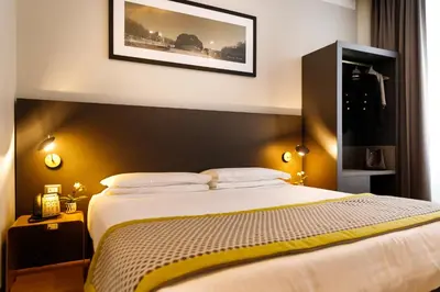 a bedroom with a large bed with a black headboard at The Cross Hotel in Rome
