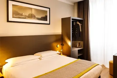 a bedroom with a bed and a picture on the wall at The Cross Hotel in Rome